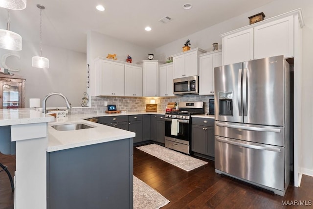 kitchen featuring gray cabinetry, stainless steel appliances, sink, white cabinetry, and hanging light fixtures