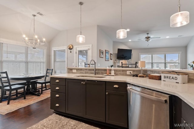 kitchen with dishwasher, sink, decorative light fixtures, lofted ceiling, and ceiling fan with notable chandelier