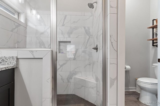 bathroom featuring vanity, toilet, and a shower with door