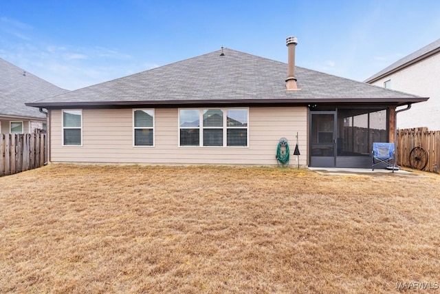 back of property with a patio, a sunroom, and a lawn