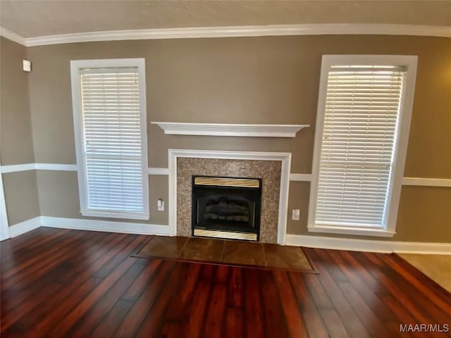 unfurnished living room featuring a fireplace, wood-type flooring, and ornamental molding