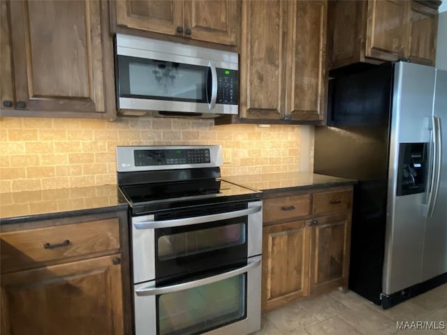 kitchen with appliances with stainless steel finishes and tasteful backsplash