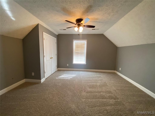 bonus room featuring carpet flooring, a textured ceiling, ceiling fan, and lofted ceiling