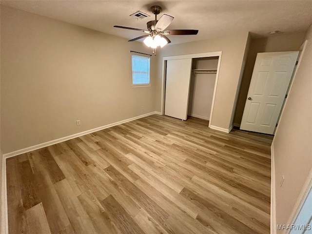 unfurnished bedroom with hardwood / wood-style floors, ceiling fan, and a closet