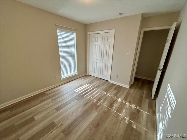 unfurnished bedroom with light hardwood / wood-style floors and a closet