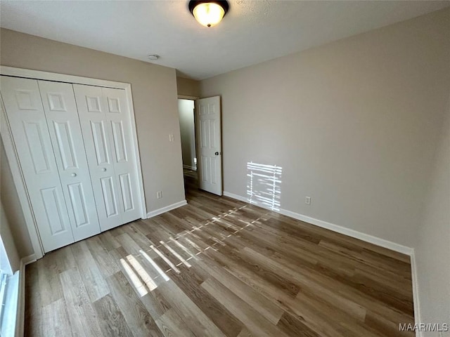 unfurnished bedroom with a closet and hardwood / wood-style flooring