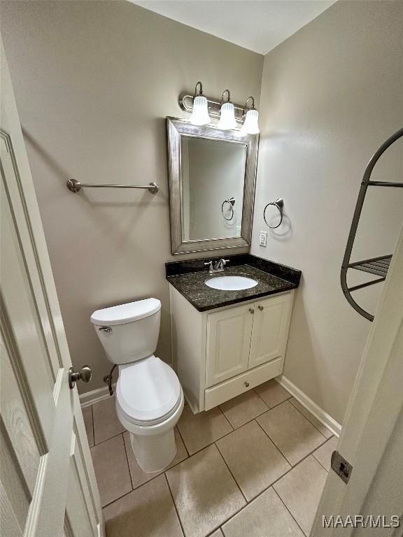 bathroom featuring tile patterned floors, vanity, and toilet