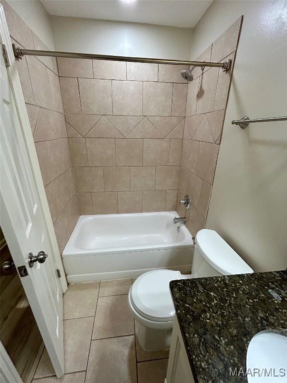 full bathroom featuring tile patterned floors, vanity, toilet, and tiled shower / bath combo