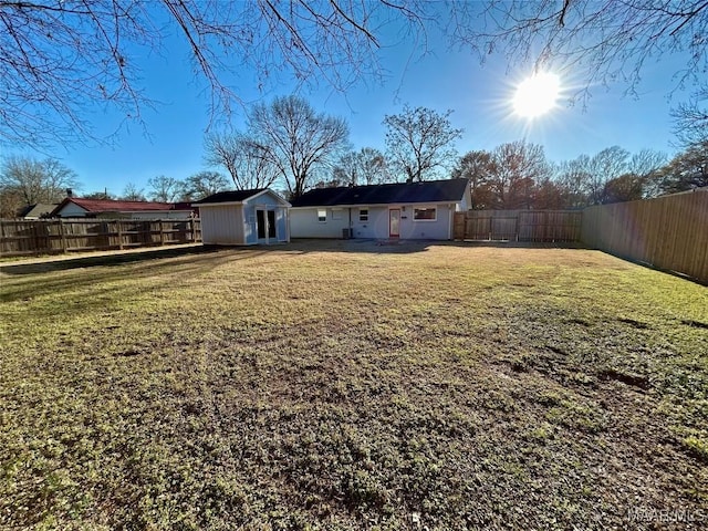 back of property with a lawn and a storage shed