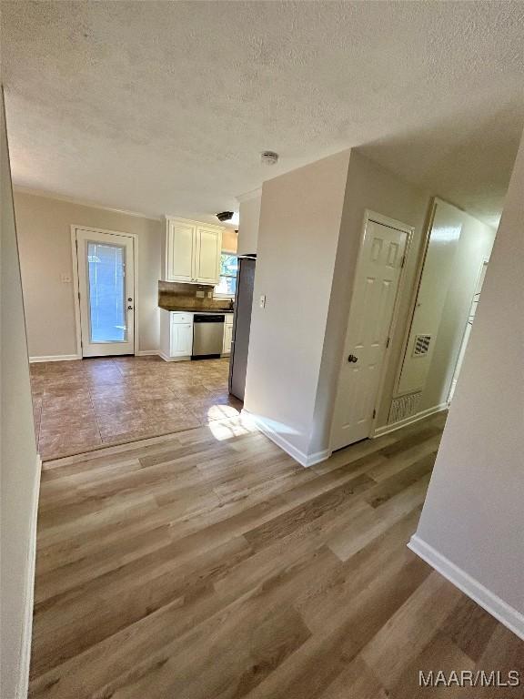 unfurnished living room featuring a textured ceiling and light hardwood / wood-style flooring