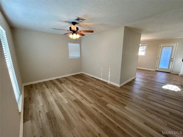 unfurnished room featuring hardwood / wood-style floors, a textured ceiling, and ceiling fan