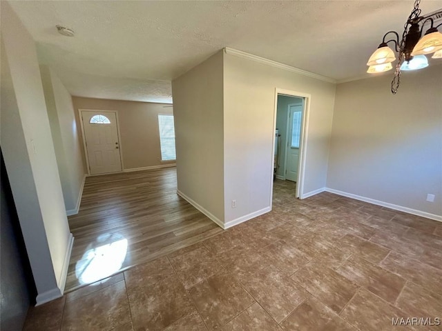 foyer entrance with a chandelier, a textured ceiling, and crown molding