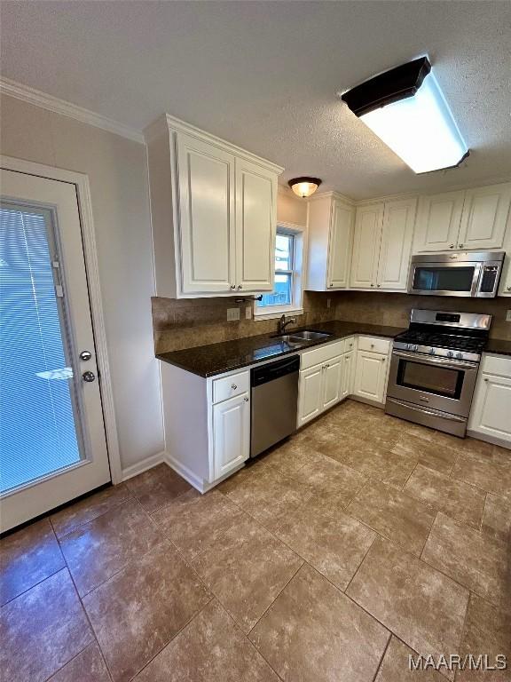 kitchen with a textured ceiling, sink, white cabinetry, and stainless steel appliances