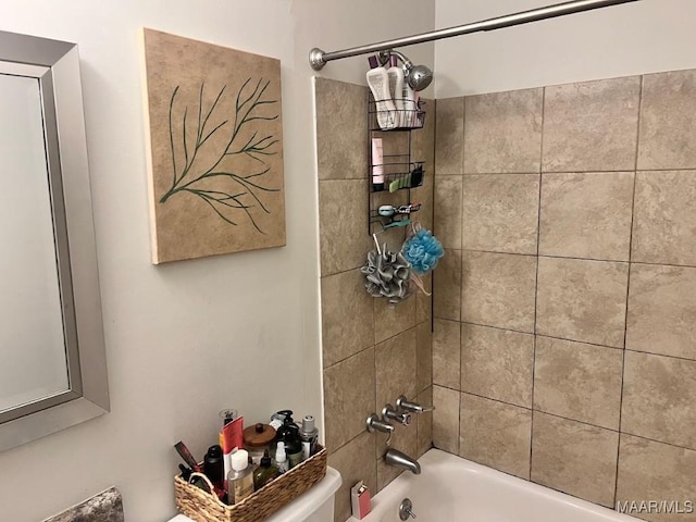 bathroom with tiled shower / bath combo and toilet