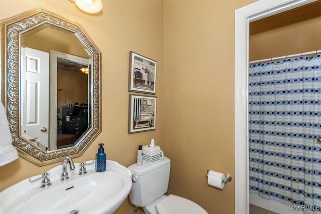 bathroom featuring toilet, ceiling fan, a shower with shower curtain, and sink