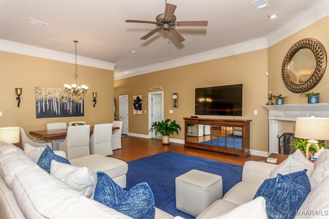 living room with ceiling fan with notable chandelier, ornamental molding, and dark hardwood / wood-style floors