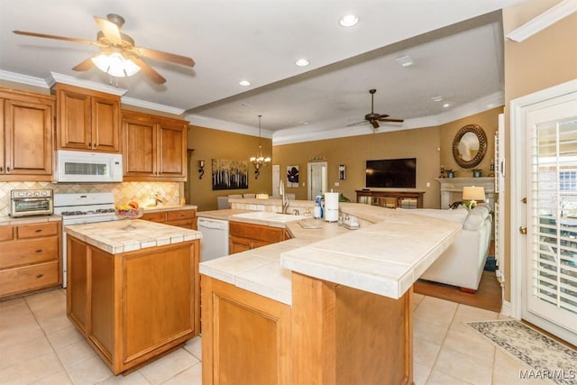 kitchen with white appliances, pendant lighting, tile countertops, and a spacious island