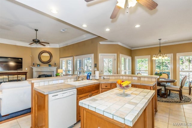 kitchen featuring tile countertops, dishwasher, sink, and a kitchen island with sink