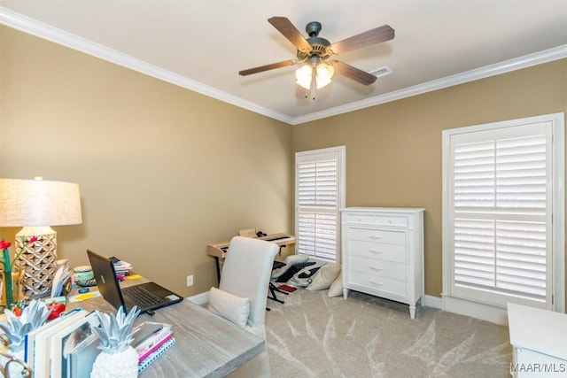 carpeted home office featuring ceiling fan, ornamental molding, and a wealth of natural light