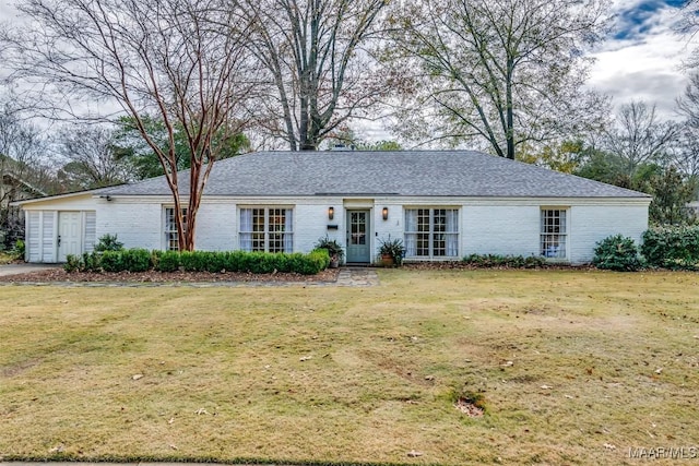 single story home featuring a front yard, a shingled roof, and brick siding