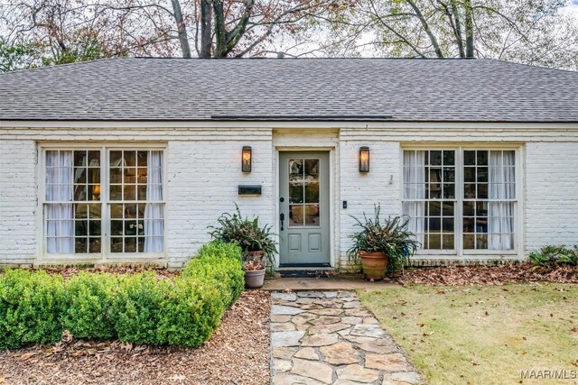 doorway to property featuring a lawn