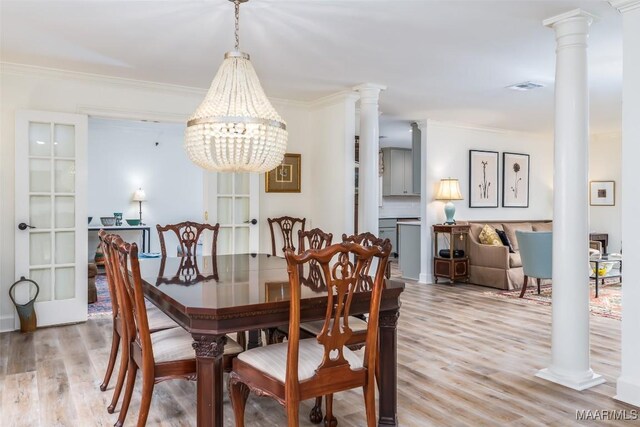 dining room featuring visible vents, an inviting chandelier, ornamental molding, decorative columns, and light wood-style floors