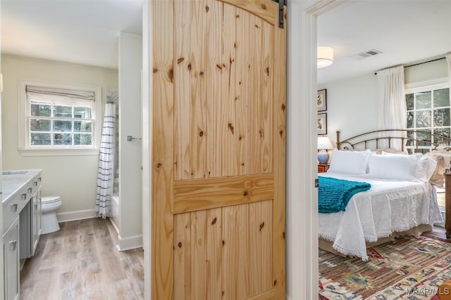 bedroom featuring light wood finished floors, baseboards, and visible vents