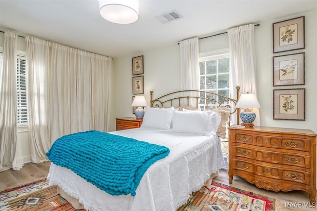 bedroom featuring wood finished floors and visible vents