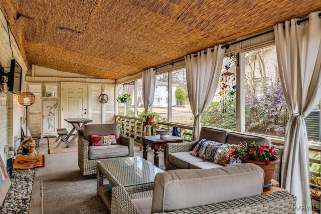 sunroom / solarium with wood ceiling, lofted ceiling, and plenty of natural light