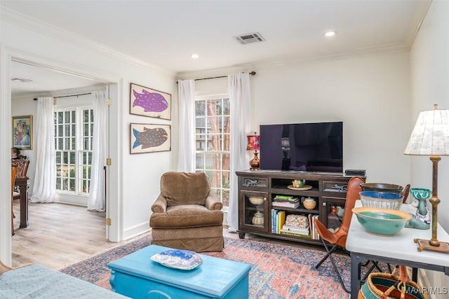 living area featuring recessed lighting, visible vents, ornamental molding, and wood finished floors