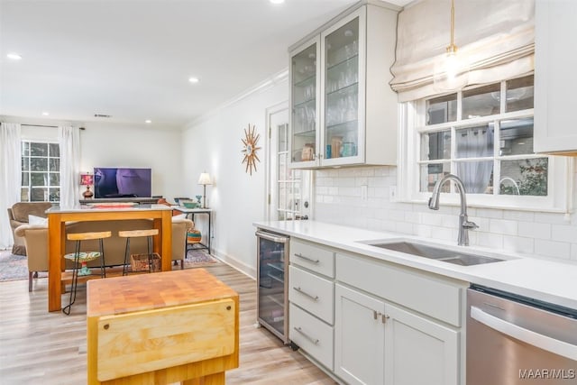 kitchen with stainless steel dishwasher, tasteful backsplash, open floor plan, and a sink