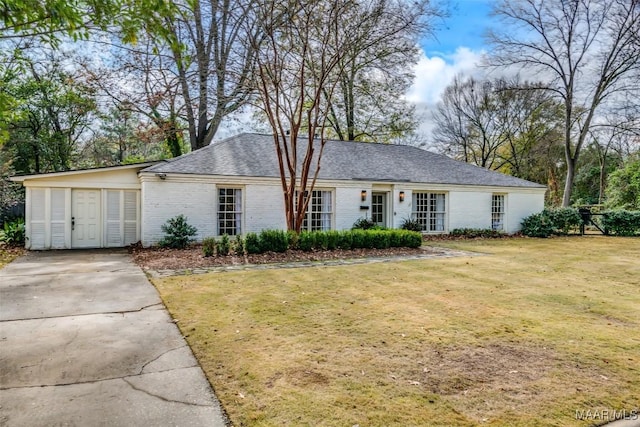 single story home with brick siding, a front lawn, and concrete driveway