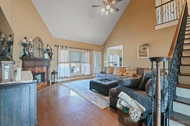 living room featuring a high end fireplace, high vaulted ceiling, ceiling fan, and dark hardwood / wood-style flooring