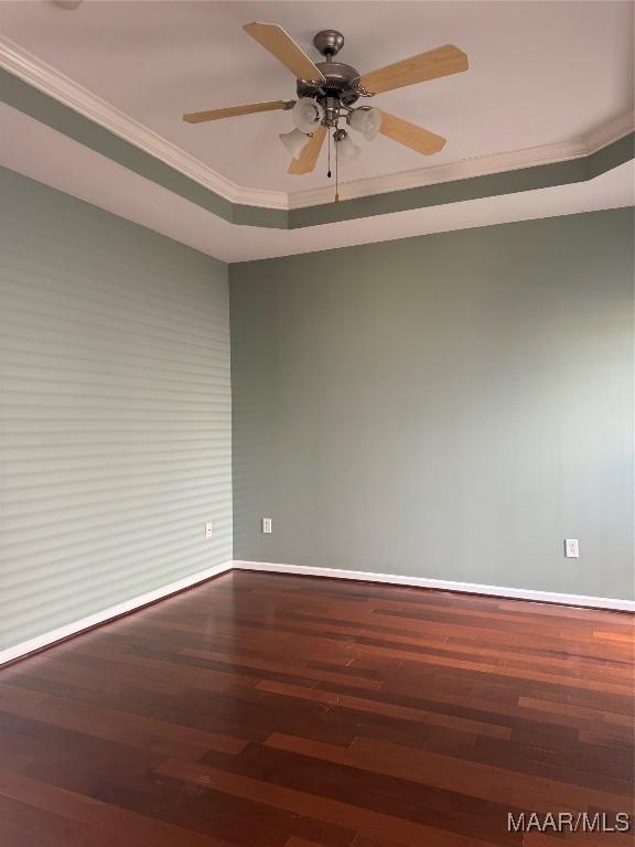 unfurnished room with ceiling fan, a tray ceiling, crown molding, and hardwood / wood-style flooring