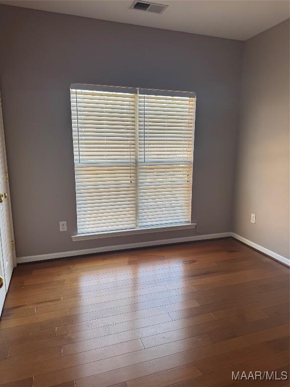 unfurnished room with dark hardwood / wood-style flooring