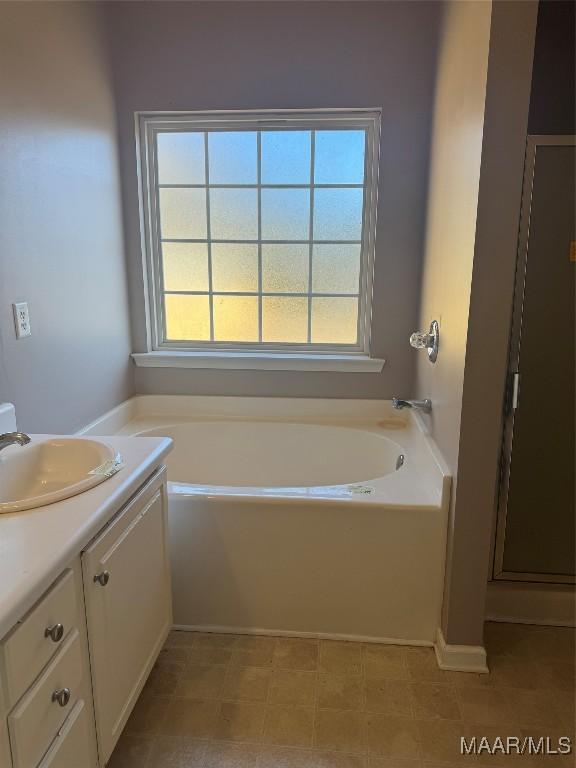 bathroom featuring vanity and a tub