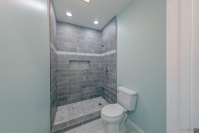 bathroom with tiled shower and toilet