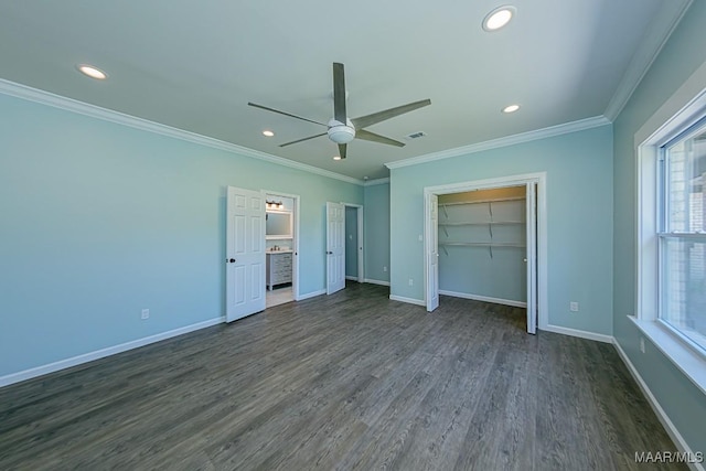 unfurnished bedroom with a spacious closet, ceiling fan, crown molding, and dark hardwood / wood-style flooring