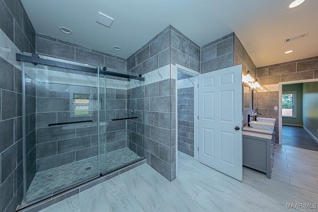 bathroom featuring tile walls, vanity, and a shower with shower door