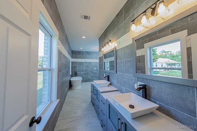 bathroom featuring vanity, tile walls, and a bathing tub