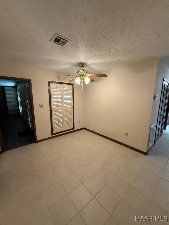 unfurnished room featuring ceiling fan and a textured ceiling