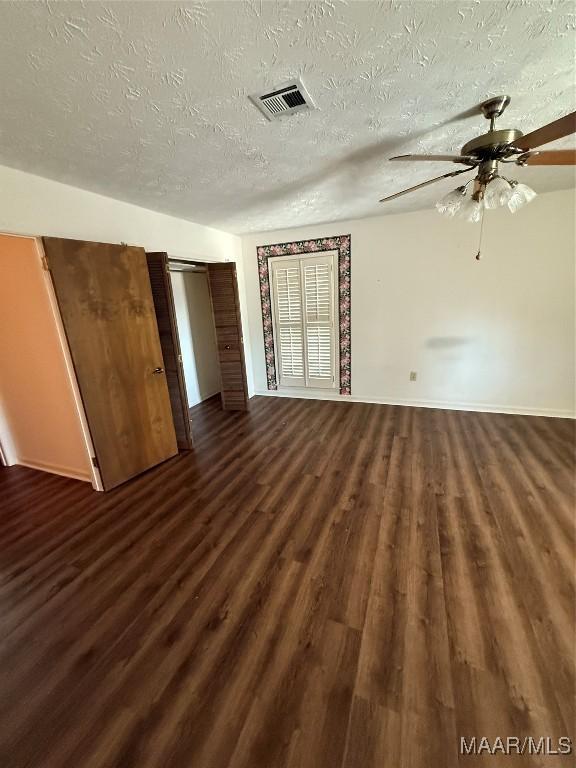 interior space with dark wood-type flooring, a textured ceiling, and ceiling fan