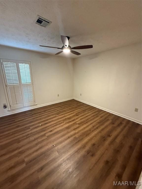 spare room featuring ceiling fan and dark wood-type flooring