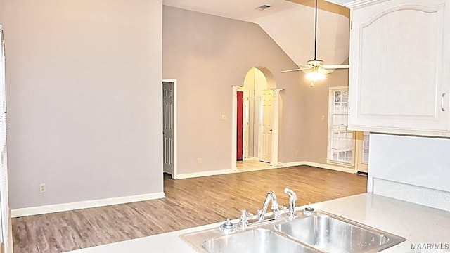 kitchen with sink, white cabinets, lofted ceiling, ceiling fan, and hardwood / wood-style floors