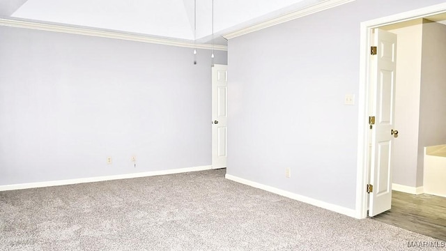 carpeted empty room featuring ornamental molding and lofted ceiling