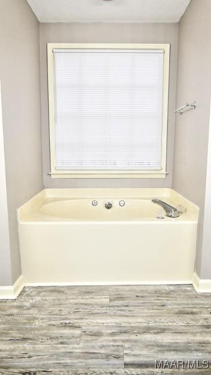 bathroom featuring wood-type flooring and a bathing tub