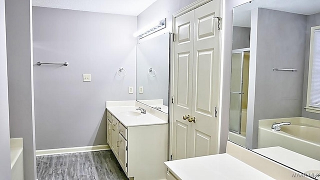 bathroom with wood-type flooring, vanity, and plus walk in shower