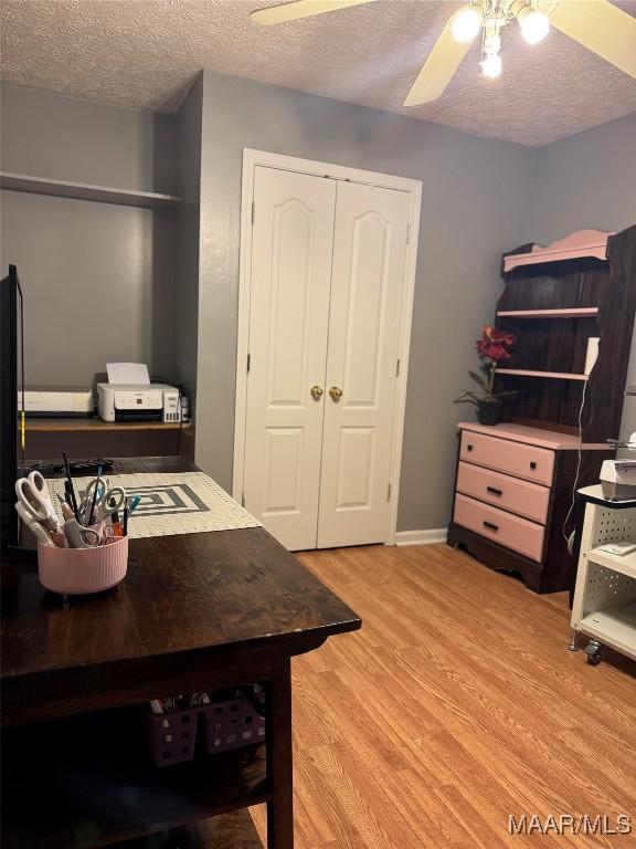 office space with ceiling fan, light hardwood / wood-style floors, and a textured ceiling