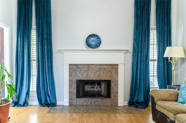 living room featuring a tiled fireplace and light hardwood / wood-style flooring