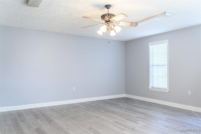 unfurnished room featuring a textured ceiling, ceiling fan, and light hardwood / wood-style flooring